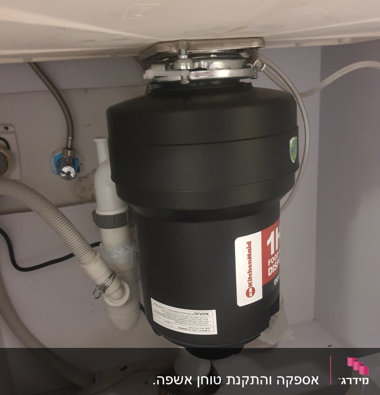 מטחנת אשפה מתחת לכיור עם צינורות חיבור